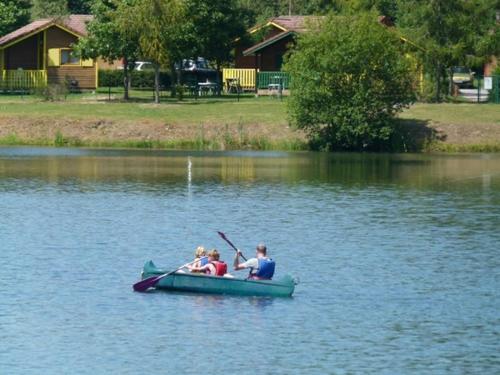 a group of people in a canoe on a lake at Camping Base de Loisirs du Lac de la Moselotte in Saulxures-sur-Moselotte