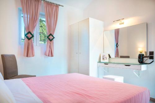 a bedroom with a pink bed and a mirror at Cypress Garden Villas in Svoronata