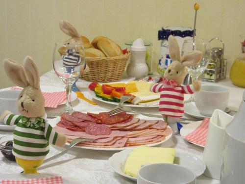 two rabbits are sitting at a table with food at Hotel Haus Orchideental Jena in Jena