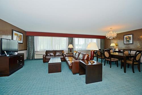 a living room with a couch and a dining room at Causeway Bay Hotel in Lansing