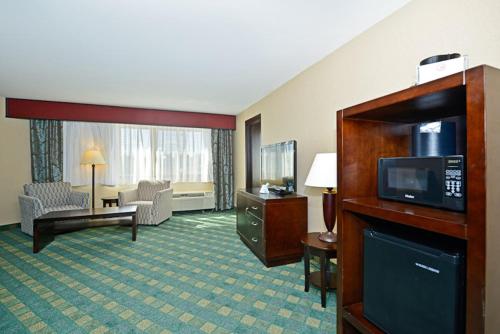 a hotel room with a television and a living room at Causeway Bay Hotel in Lansing