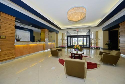 a lobby with a table and chairs and a bar at Causeway Bay Hotel in Lansing