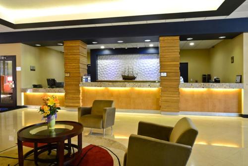 a lobby with a waiting area with chairs and a table at Causeway Bay Hotel in Lansing
