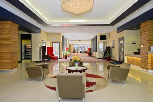a lobby with a table and chairs in a building at Causeway Bay Hotel in Lansing