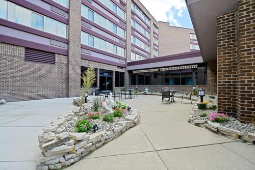 a building with a courtyard with flowers in front of it at Causeway Bay Hotel in Lansing