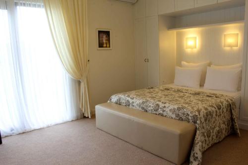 a bedroom with a bed with white sheets and white pillows at Ambassadori Kachreti Golf Resort in Kachretʼi