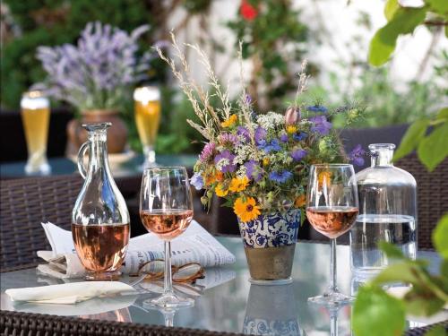 een tafel met twee glazen wijn en een vaas met bloemen bij Hotel Krone in Ostfildern