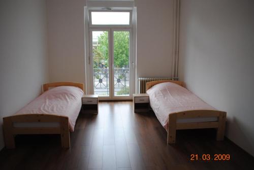 2 camas en una habitación con ventana en Monteurzimmer-Apartment Scholl Pforzheim en Pforzheim