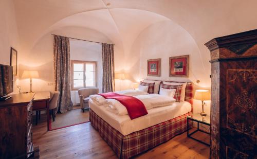 a bedroom with a bed and a desk in a room at Mellauner Hof in Pettnau