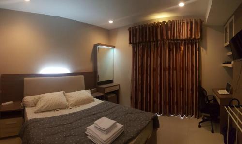 - une chambre avec un lit et des serviettes dans l'établissement Jakarta Residence, à Jakarta