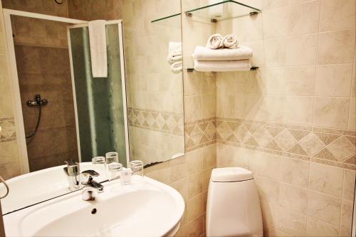 a bathroom with a sink and a mirror and a toilet at NB Hotel with Free Parking in Rīga