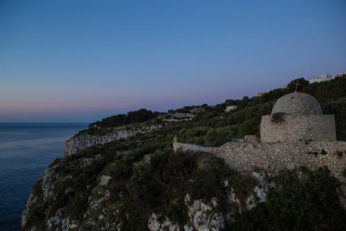 an old building on a cliff next to the ocean at Hotel Piccolo Mondo in Castro di Lecce