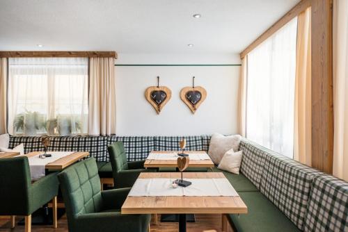 a restaurant with couches and tables and hearts on the wall at Hotel Hubertushof in Lermoos