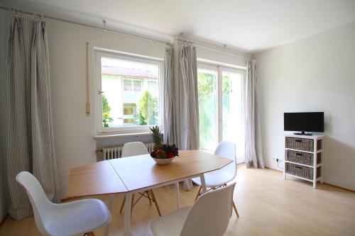 une salle à manger avec une table en bois et des chaises blanches dans l'établissement Berglust, à Garmisch-Partenkirchen