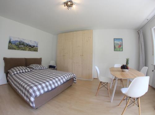 - une chambre avec un lit, une table et des chaises dans l'établissement Berglust, à Garmisch-Partenkirchen