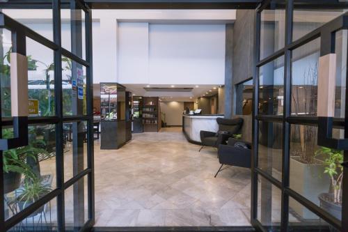 a lobby of a building with glass windows and a lobby at Maxim's Inn in Bangkok
