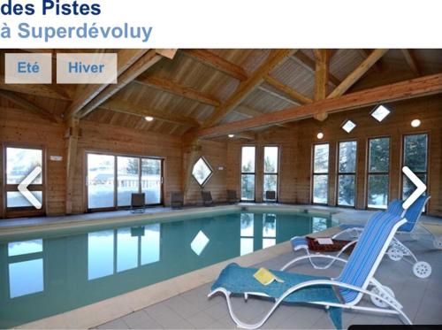 代沃呂伊的住宿－Station de ski Superdevoluy du bois d aurouze，一个带椅子的大型游泳池和一个游泳池
