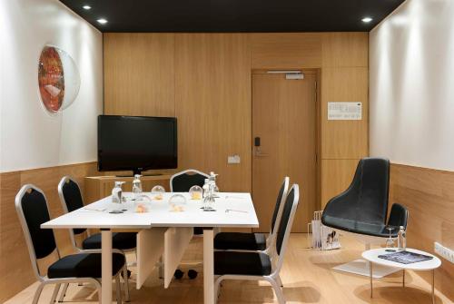 a conference room with a white table and chairs at Barceló Sants in Barcelona