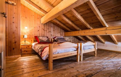 サン・マルタン・ド・ベルヴィルにあるOdalys Chalet Loutantinの木造キャビン内のベッド1台が備わるベッドルーム1室を利用します。