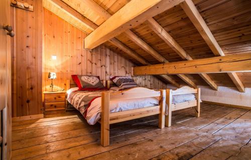 une chambre avec un lit dans une cabane en bois dans l'établissement Odalys Chalet Loutantin, à Saint-Martin-de-Belleville