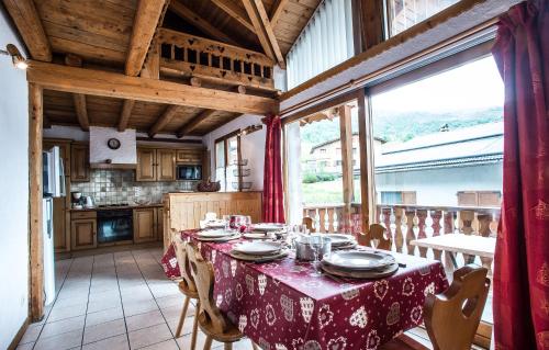 a dining room with a table and a kitchen at Odalys Chalet Loutantin in Saint-Martin-de-Belleville
