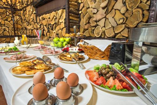 a table with plates of food and eggs on it at Uniqato Hotel in Stara Zagora