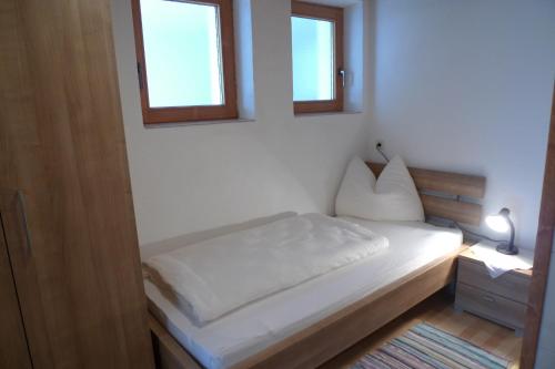 una piccola camera con un letto e due finestre di Single Apartment Martlerhof a Tux