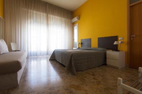 a bedroom with two beds and a yellow wall at Artemisia in Vittoria