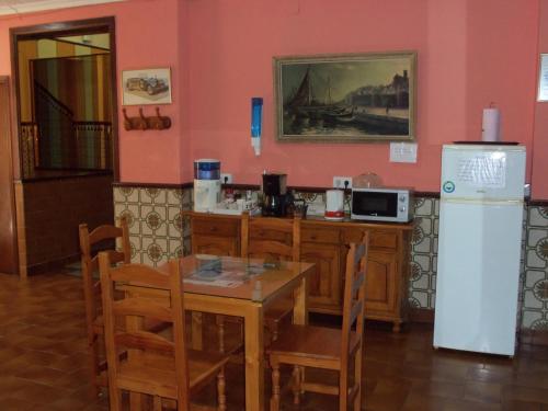 een eetkamer met een tafel en een koelkast bij La Esteponera in La Línea de la Concepción