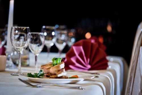 a plate of food on a table with wine glasses at Ośrodek Wypoczynkowy Marymont przy Dolinie Kościeliskiej in Kościelisko