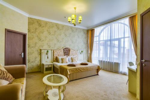 クラスノダールにあるHotel Palazzo Krasnodarのベッドルーム(ベッド1台、ソファ付)