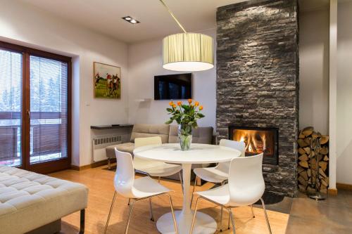 コシチェリスコにあるudanypobyt Apartamenty Słoneczneのリビングルーム(テーブル、椅子、暖炉付)