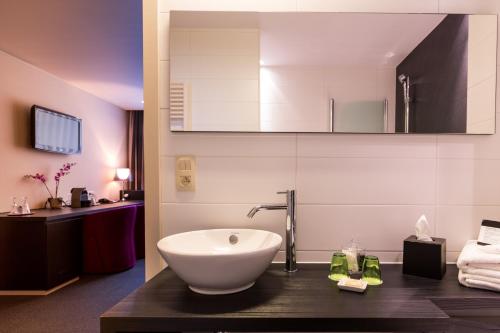 a bathroom with a white bowl sink on a counter at Hotel Royal in De Panne