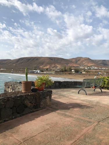 a view of a beach with a bench and a plant at Casita Lanzaocean view in Punta de Mujeres
