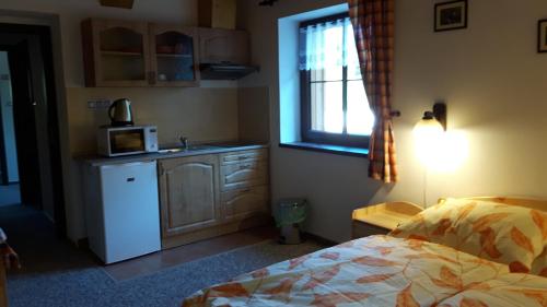 a bedroom with a bed and a sink and a window at Chata u Tří Sluk in Modrava