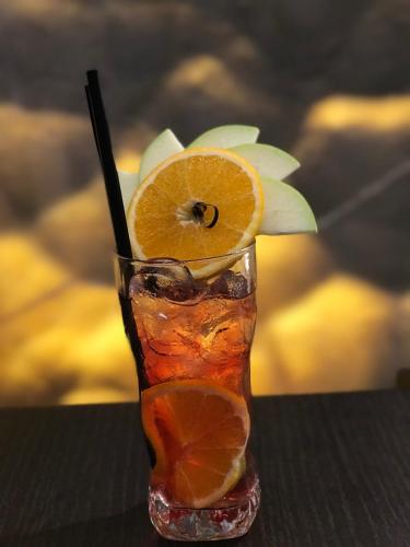 a glass vase with an orange slice on a table at Hotel Colosseo Tirana in Tirana