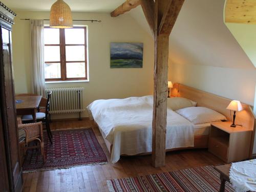 a bedroom with a bed and a table and a window at Cozy Apartment in Buschenhagen with Sauna in Buschenhagen