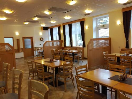 a dining room with wooden tables and chairs at Hotel Berounka in Liblín