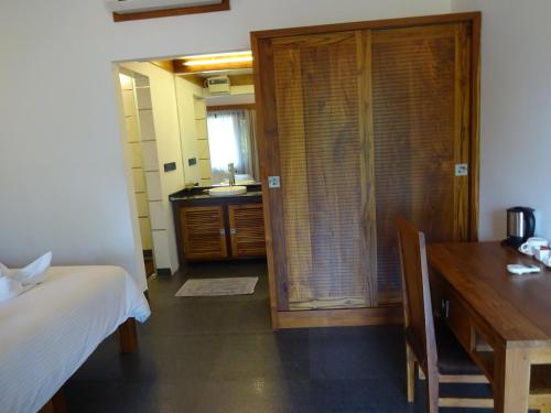 um quarto com uma cama, uma secretária e uma cozinha em Dunhill Beach Resort em Agonda