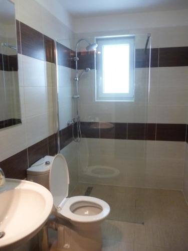 a bathroom with a toilet and a sink and a window at Pension Pugner in Vysoké nad Jizerou