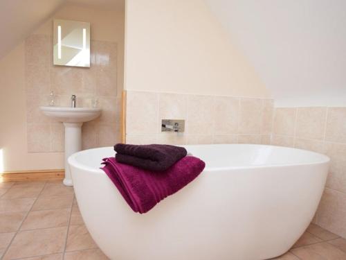 a bathroom with a large white tub and a sink at Mallows Byre Yetminster in Sherborne