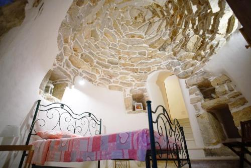 a bedroom with a bed and a stone wall at Villa Le Macchie in Torre Vado