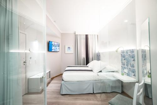 a white bedroom with a bed and a sink at Sé Boutique Hotel in Funchal