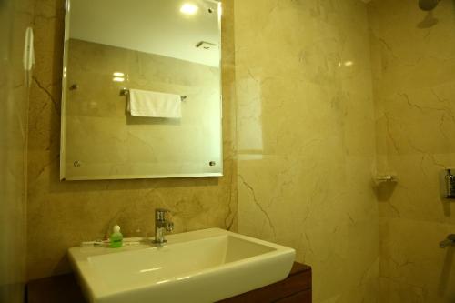 a bathroom with a sink and a mirror at Niko Hotels in Cochin