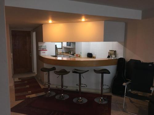 a kitchen with a bar with stools under a counter at Duplex Jacuzzi San Alfonso del Mar in Algarrobo