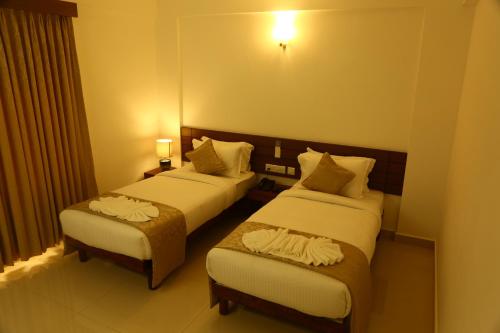 a hotel room with two beds in a room at Niko Hotels in Cochin