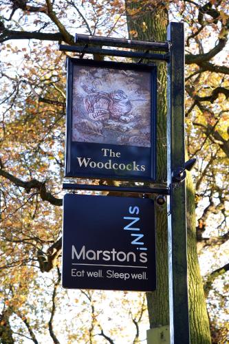 a sign for the morons on a pole next to a tree at Woodcocks, Lincoln by Marston's Inns in Lincoln