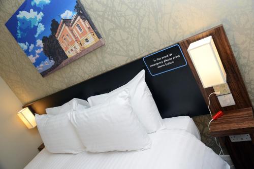 a hotel room with a bed with a sign on it at Woodcocks, Lincoln by Marston's Inns in Lincoln