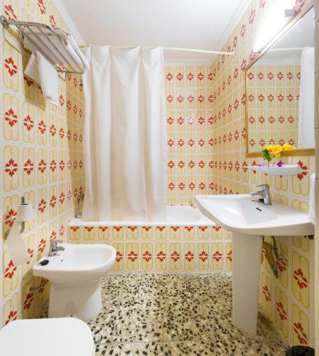 a bathroom with two sinks and a toilet at Apartamentos Green Line Bon Sol - AB Group in Playa d'en Bossa