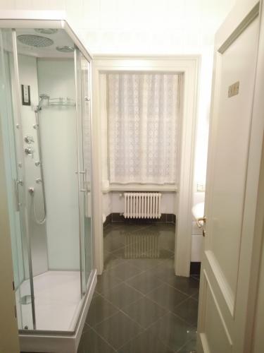 a bathroom with a glass shower and a window at Villa Lorenzo in Briosco